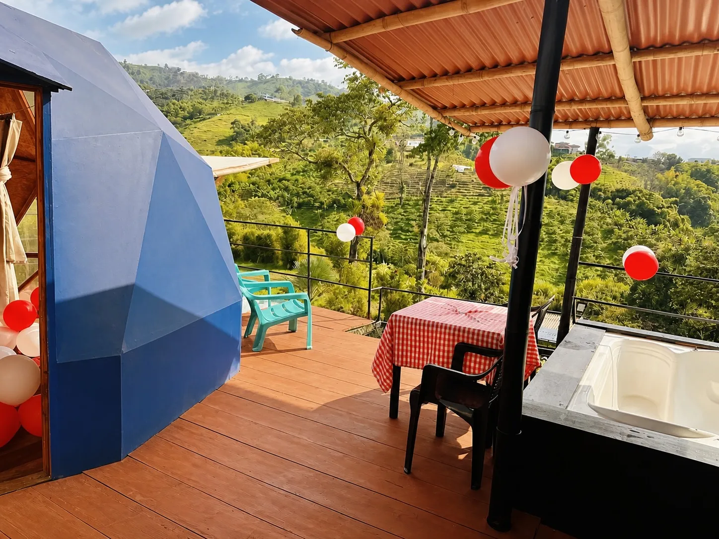 Terraza con tina de agua caliente y vista verde junto al domo azul